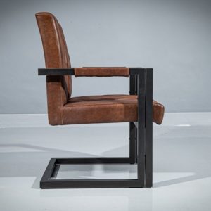 Side view of a metal dining armchair. Powder-coated metal frame in geometrical shape and dark gray matte finish. Seat and backrest upholstered in real brown leather with diamond-shape pattern.