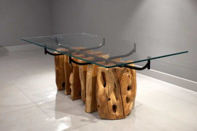 Diagonal view of a rectangual dining table. Base made of five pieces of natural solid olive wood combined with a black metal structure.